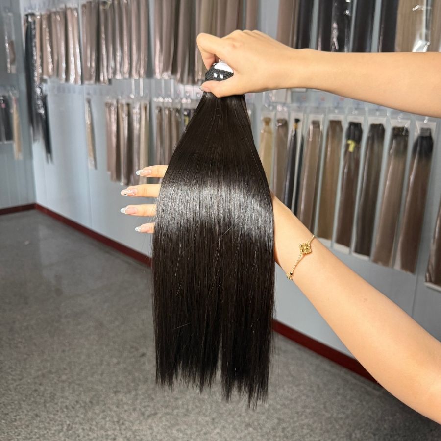WOWANGEL Double Drawn Bone Straight Bundles held up to display smooth, shiny strands and consistent thickness, ideal for natural-looking weaves.
